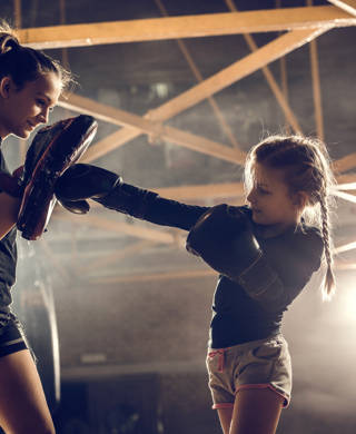 Jong meisje krijgt boksles van vrouwelijke coach